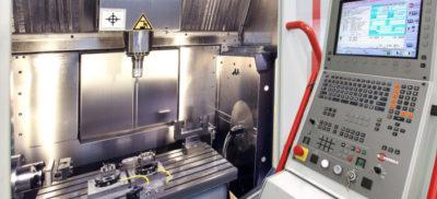 The control panel and inside view of a CNC machine