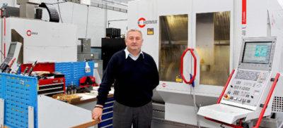 An engineer standing in front of a Hermle machine