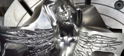 A machined metal part in the shape of a women with wings