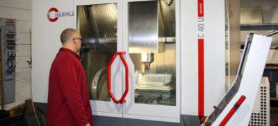 An engineer standing infront of a Hermle C40U machine