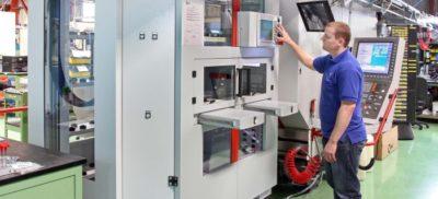 An engineer next to a Hermle machine