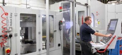 Engineer working next to a Hermle machine in a warehouse