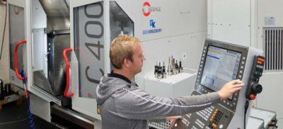 Engineer working next to a Hermle machine in a warehouse