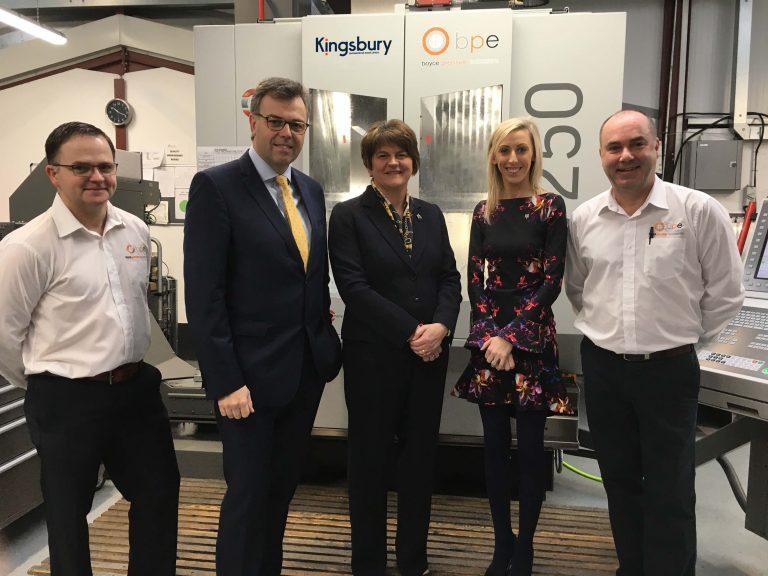 staff at subcontractor company standing in front of 5 axis machine