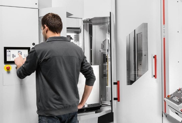 An engineer working next to a Hermle machine