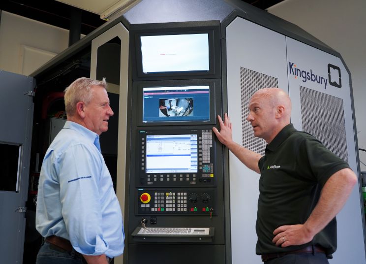 Richard Kingsbury and Additure employee talking infront of a machine