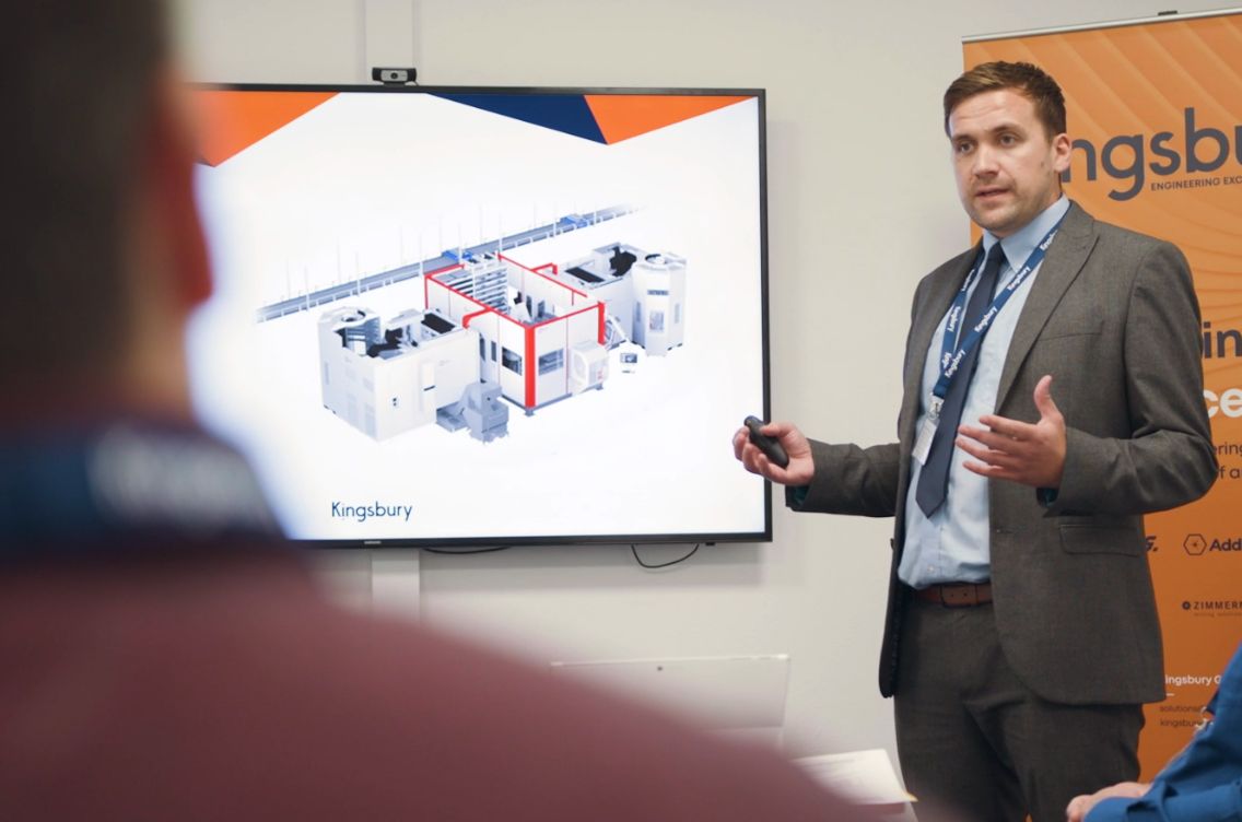 Dan Castles presenting at an event, talking in front of a crowd