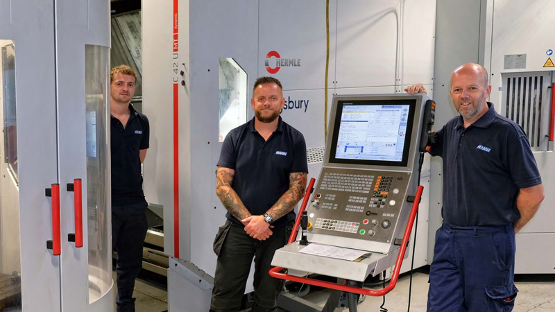 Engineers next to a Hermle machine