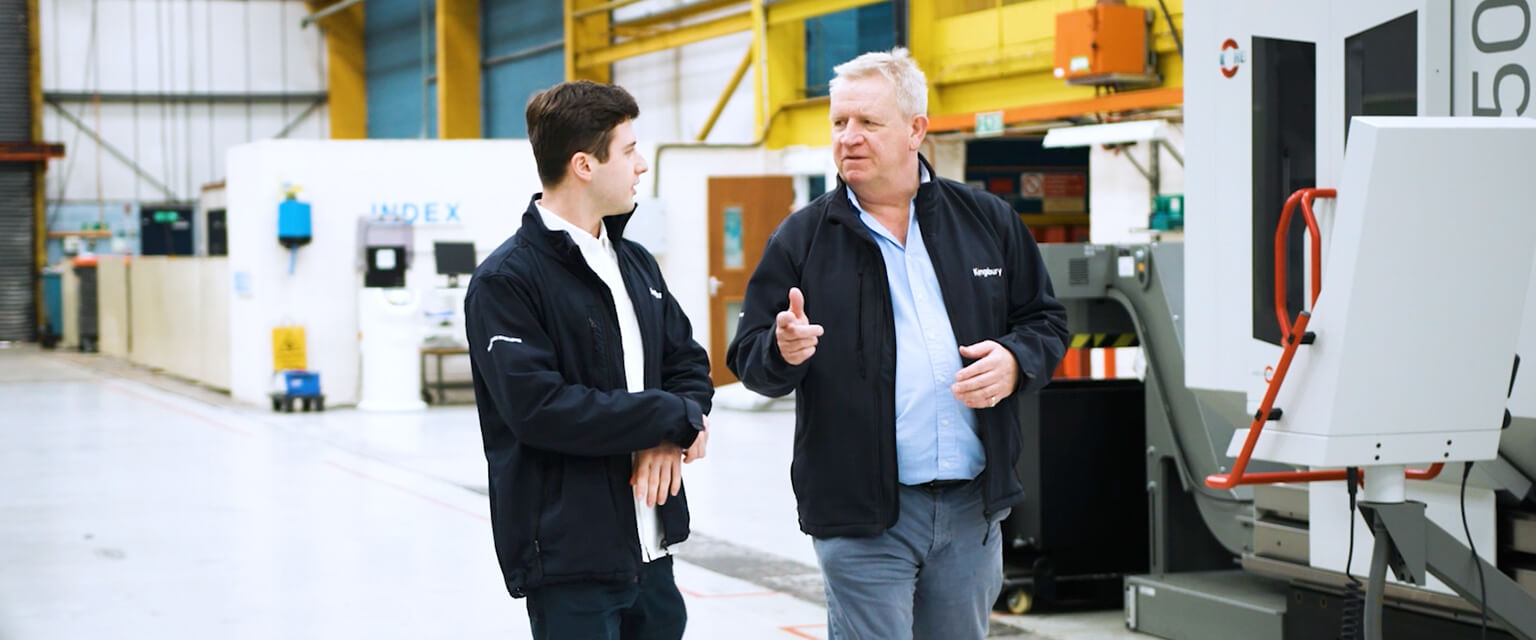 Tim Long and Richard Kingsbury talking next to CNC machines