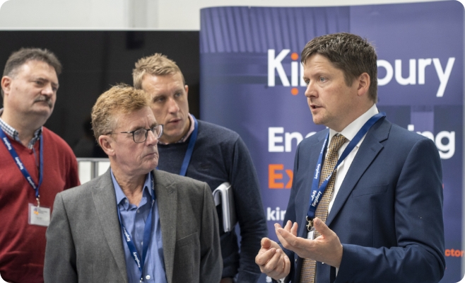 Image of Kingsbury employee talking to men at an event