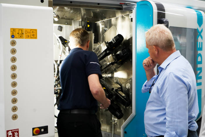 Richard Kingsbury watching an engineer work on a machine