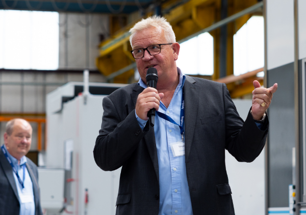 Richard Kingsbury, MD speaking in front of a machine
