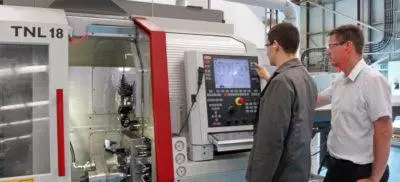 Two engineers standing infront of a CNC machine
