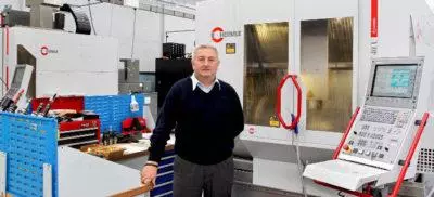 An engineer standing in front of a Hermle machine