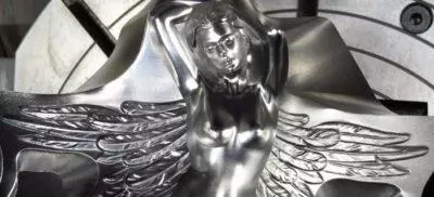 A machined metal part in the shape of a women with wings