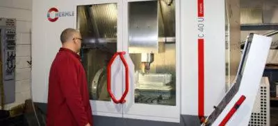 An engineer standing infront of a Hermle C40U machine