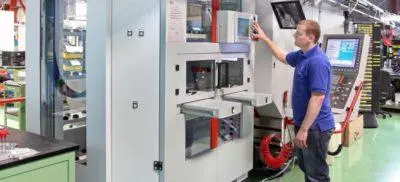 An engineer next to a Hermle machine