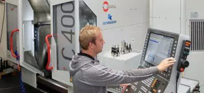 Engineer working next to a Hermle machine in a warehouse